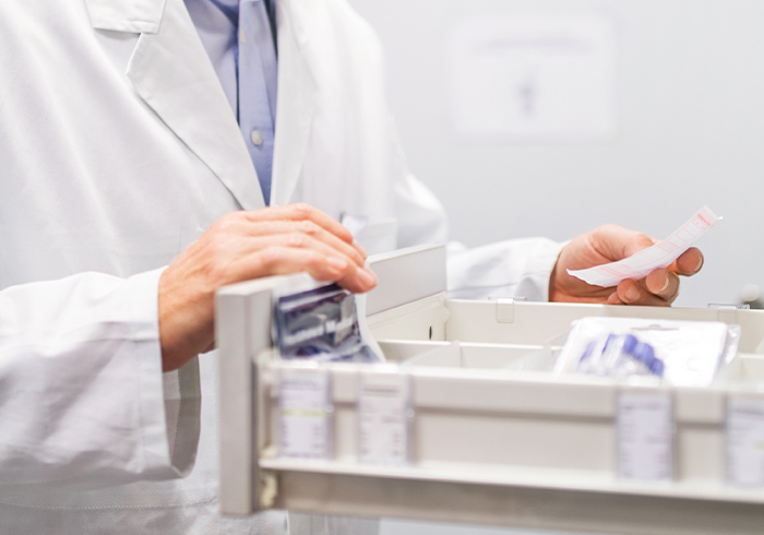 Pharmacist looking for prescribed medications in their storage.